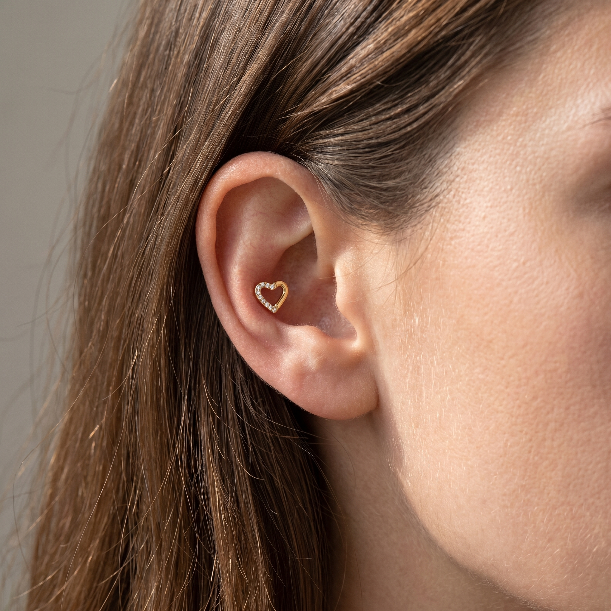 Gold open heart stud worn cleanly in an