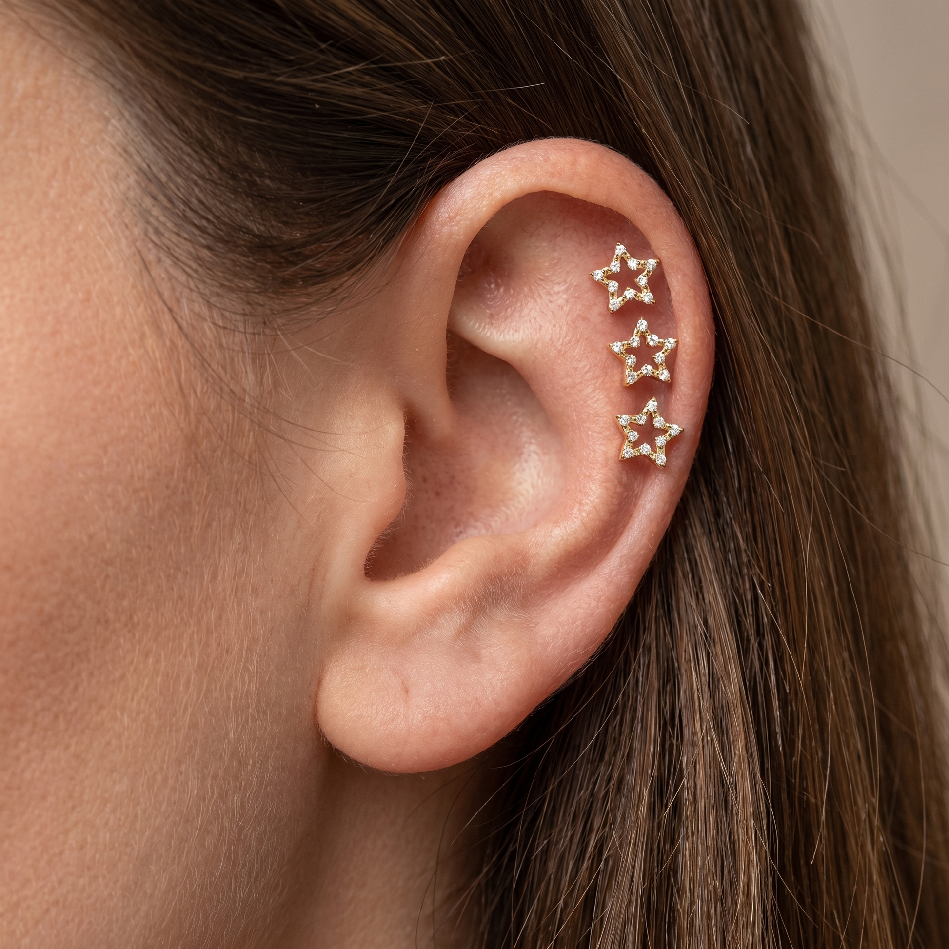 Three gold celestial cartilage studs styled in a arrangement.