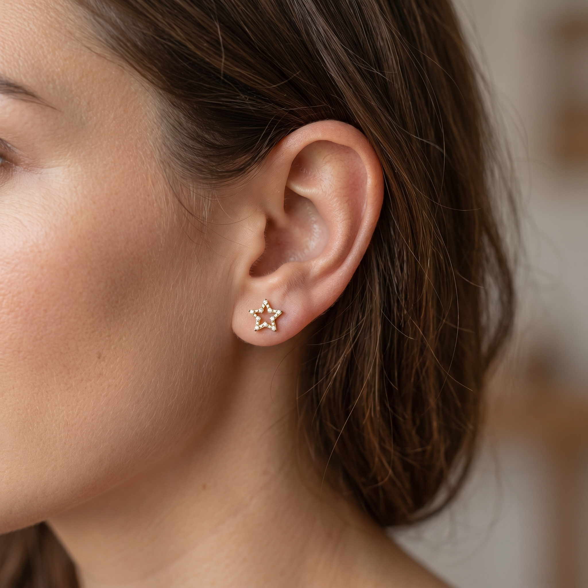 Gold open star piercing stud worn beautifully in a female .