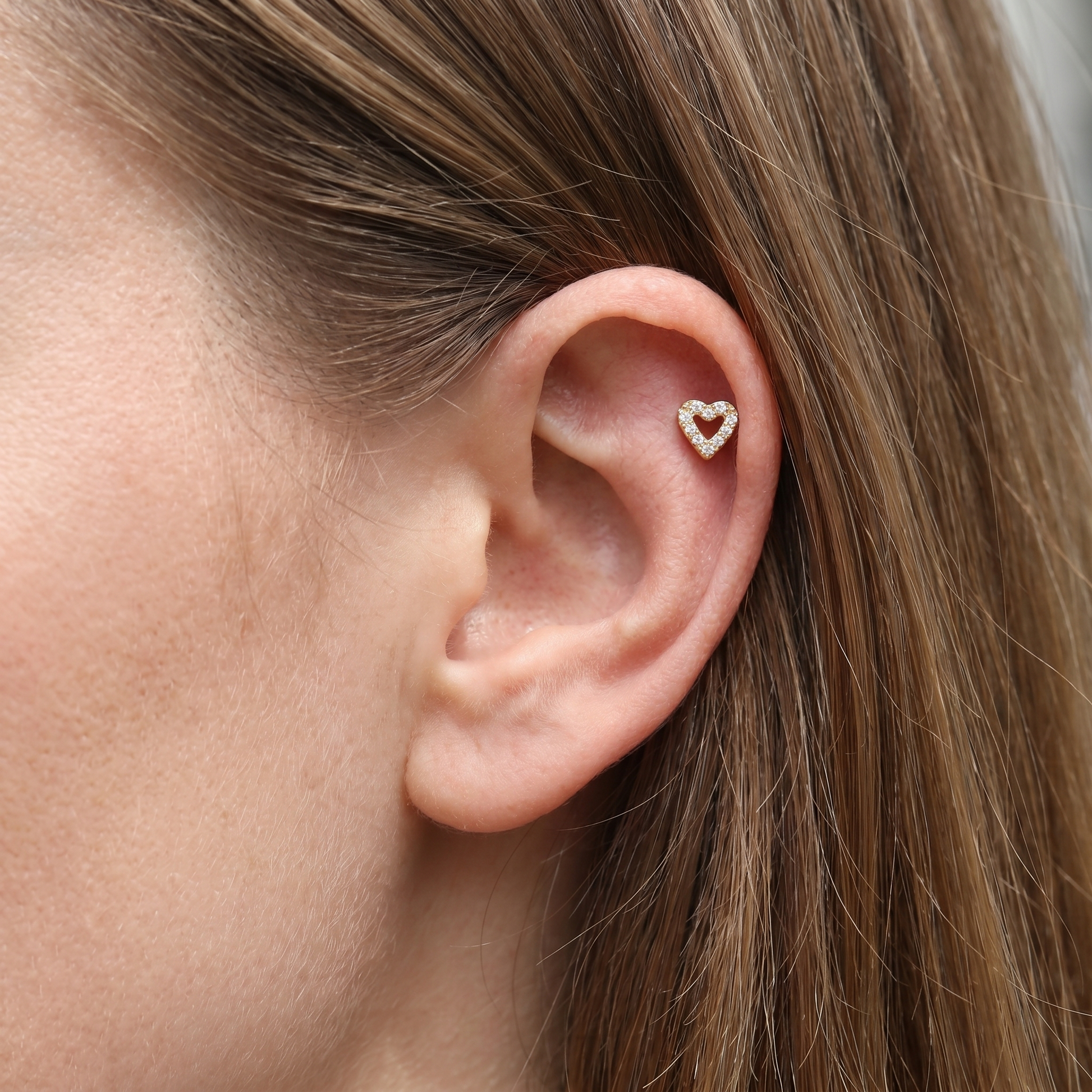 Gold titanium earring worn in a piercing.