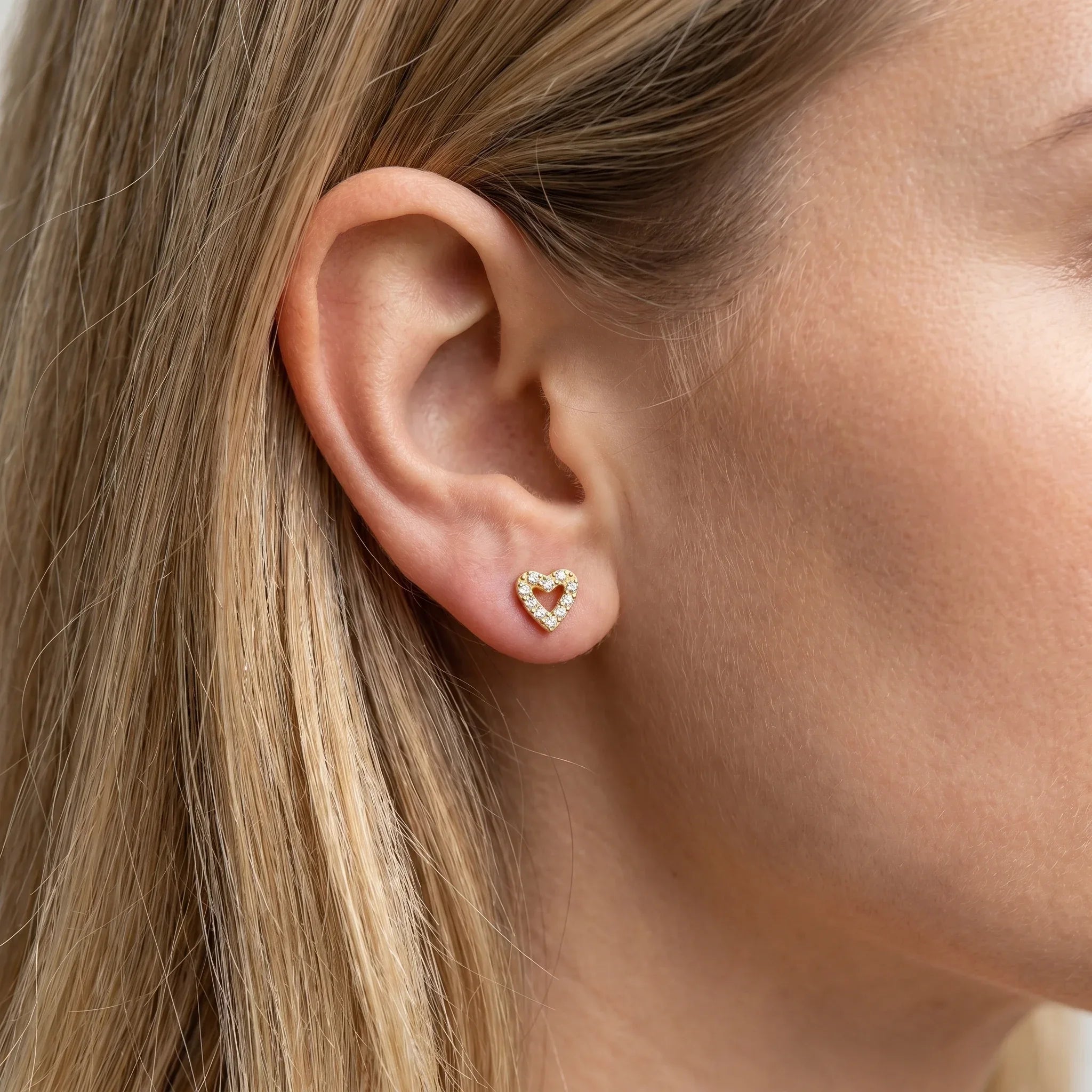 Gold romantic cartilage worn in a standard piercing.