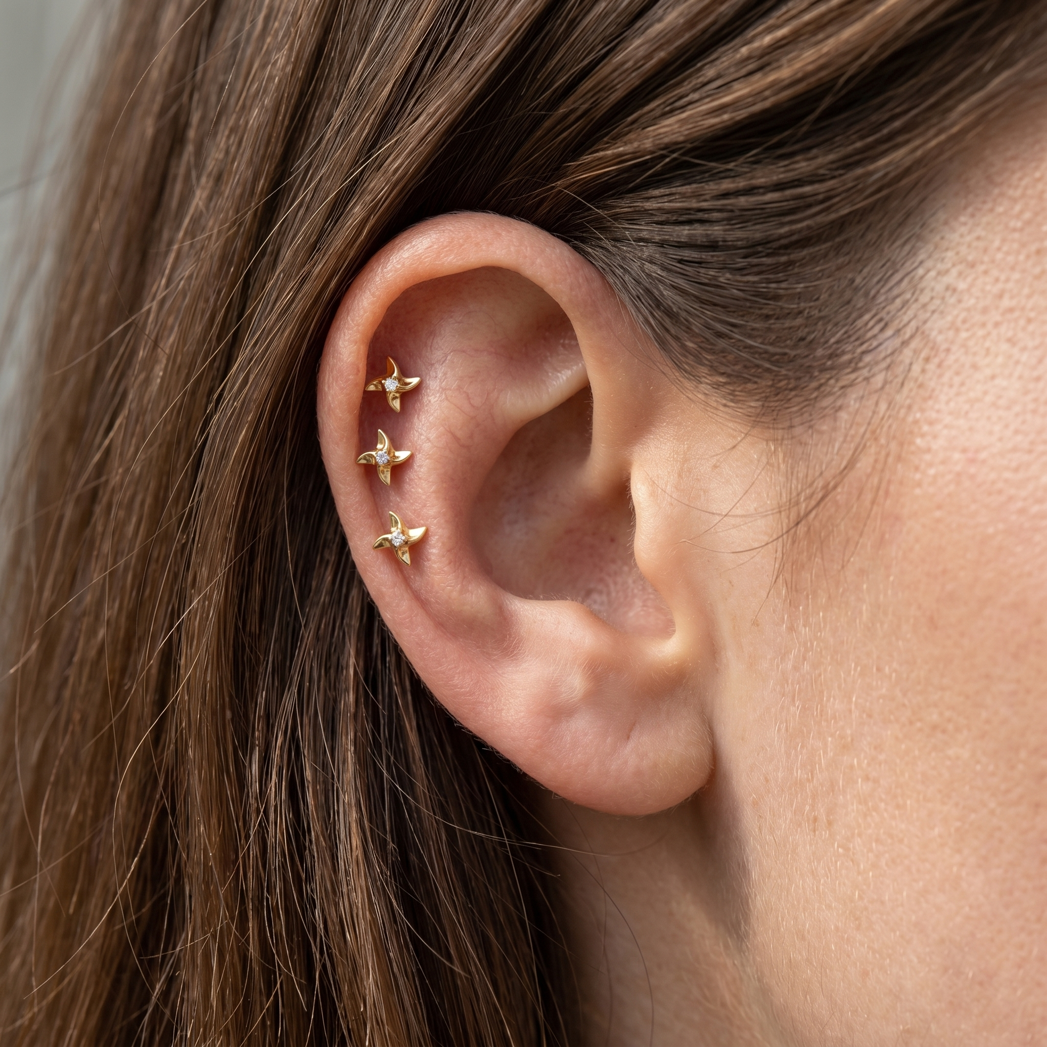 Three gold pinwheel studs worn perfectly in a arrangement.