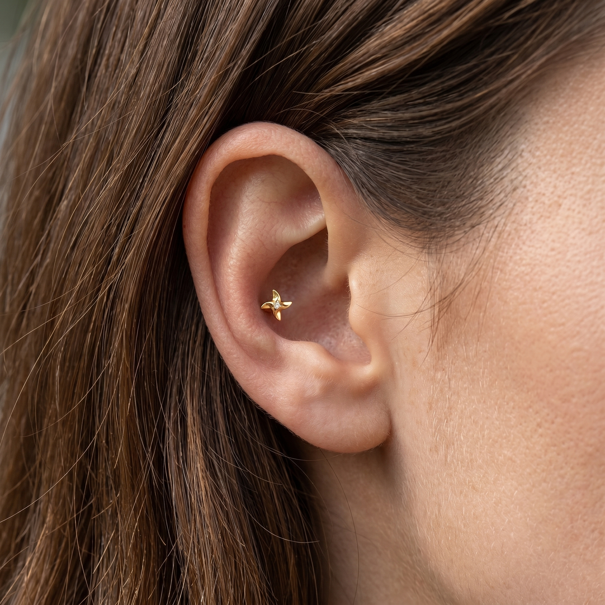 Gold medical-grade titanium piercing worn perfectly in a conch ear piercing.
