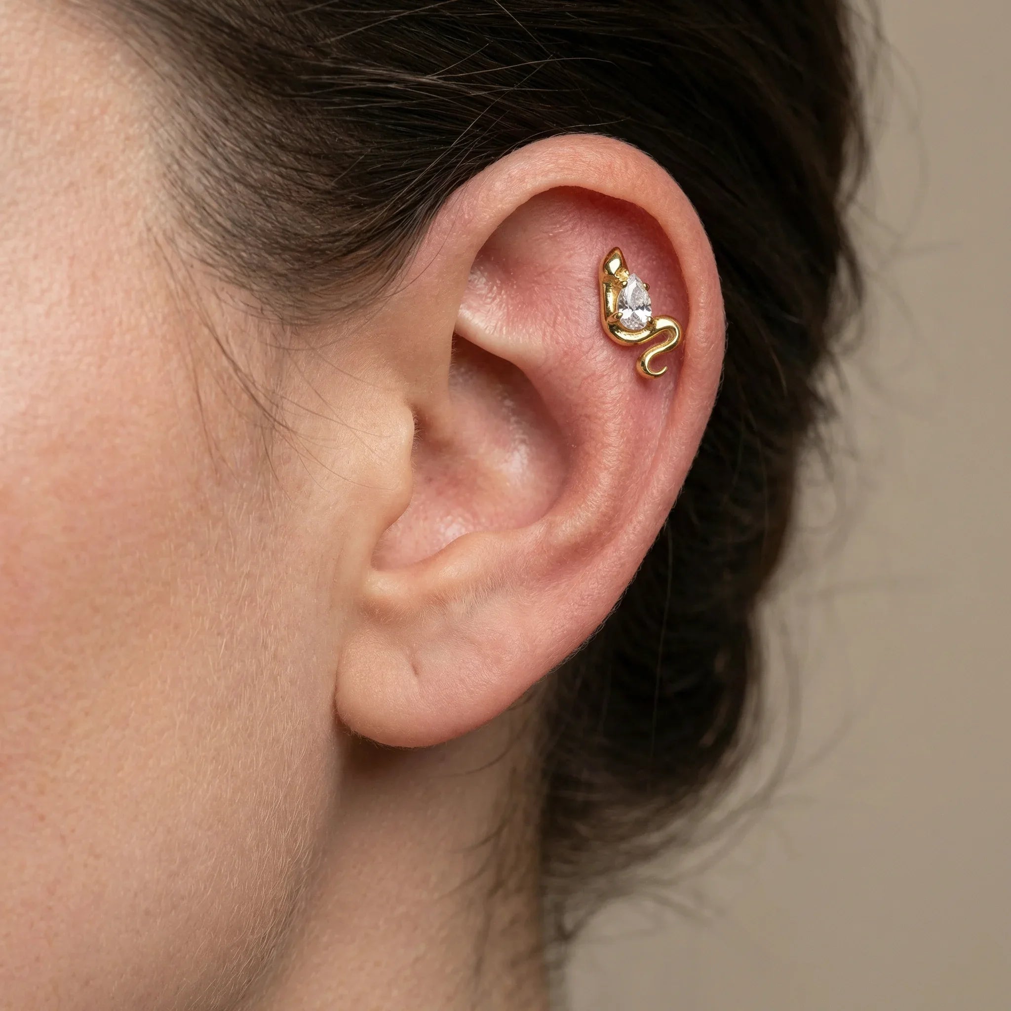 Gold snake zircon piercing jewelry styled securely in the upper flat cartilage