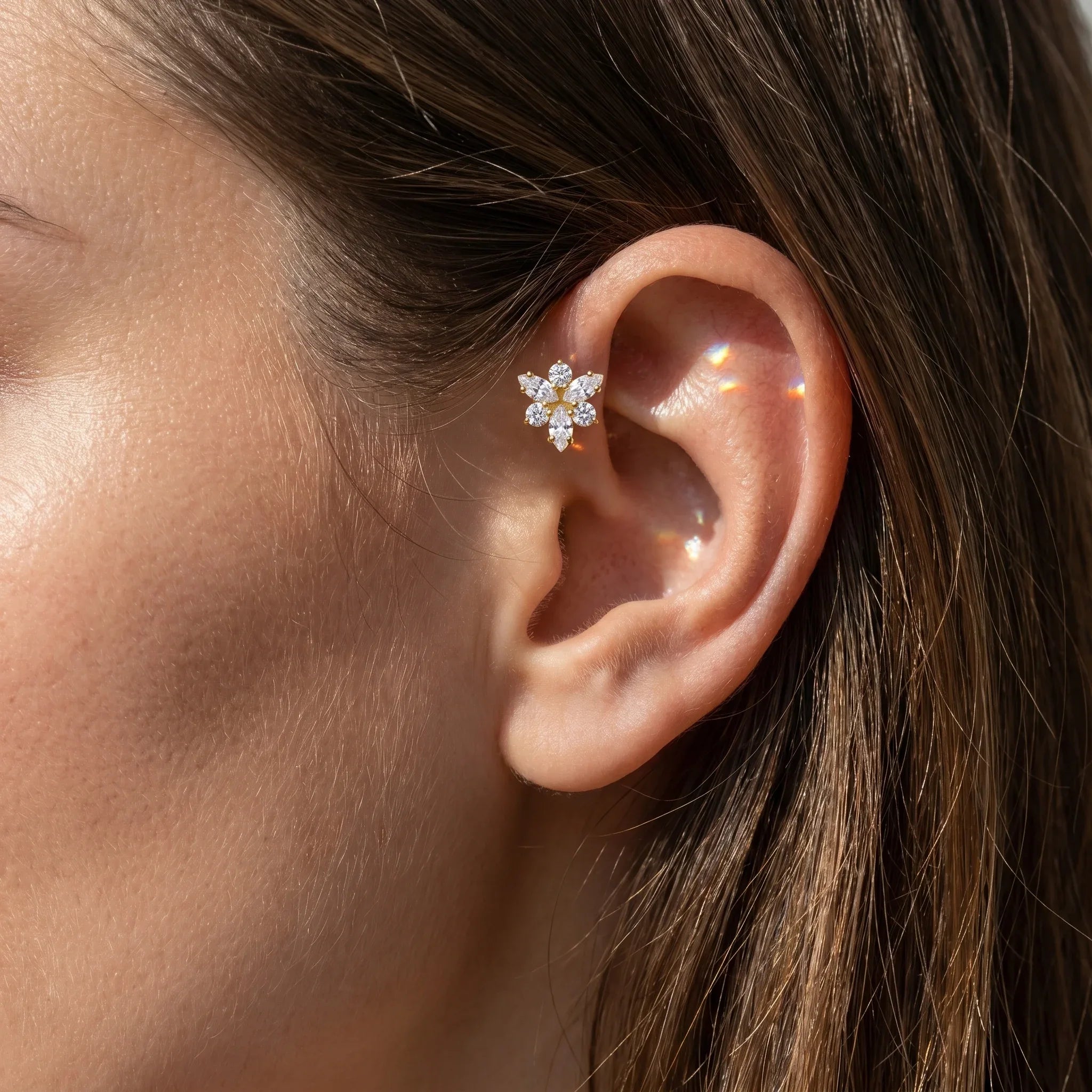 Gold snowflake cartilage stud worn elegantly in a .