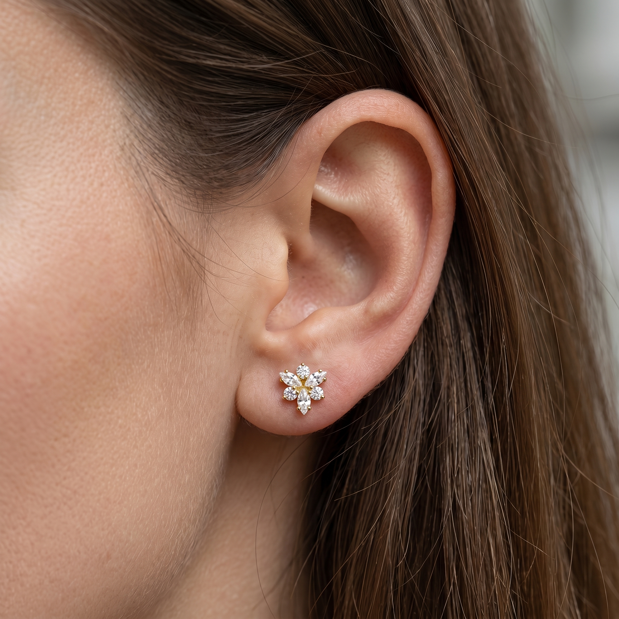 Gold snowflake cartilage stud worn beautifully in a standard piercing.