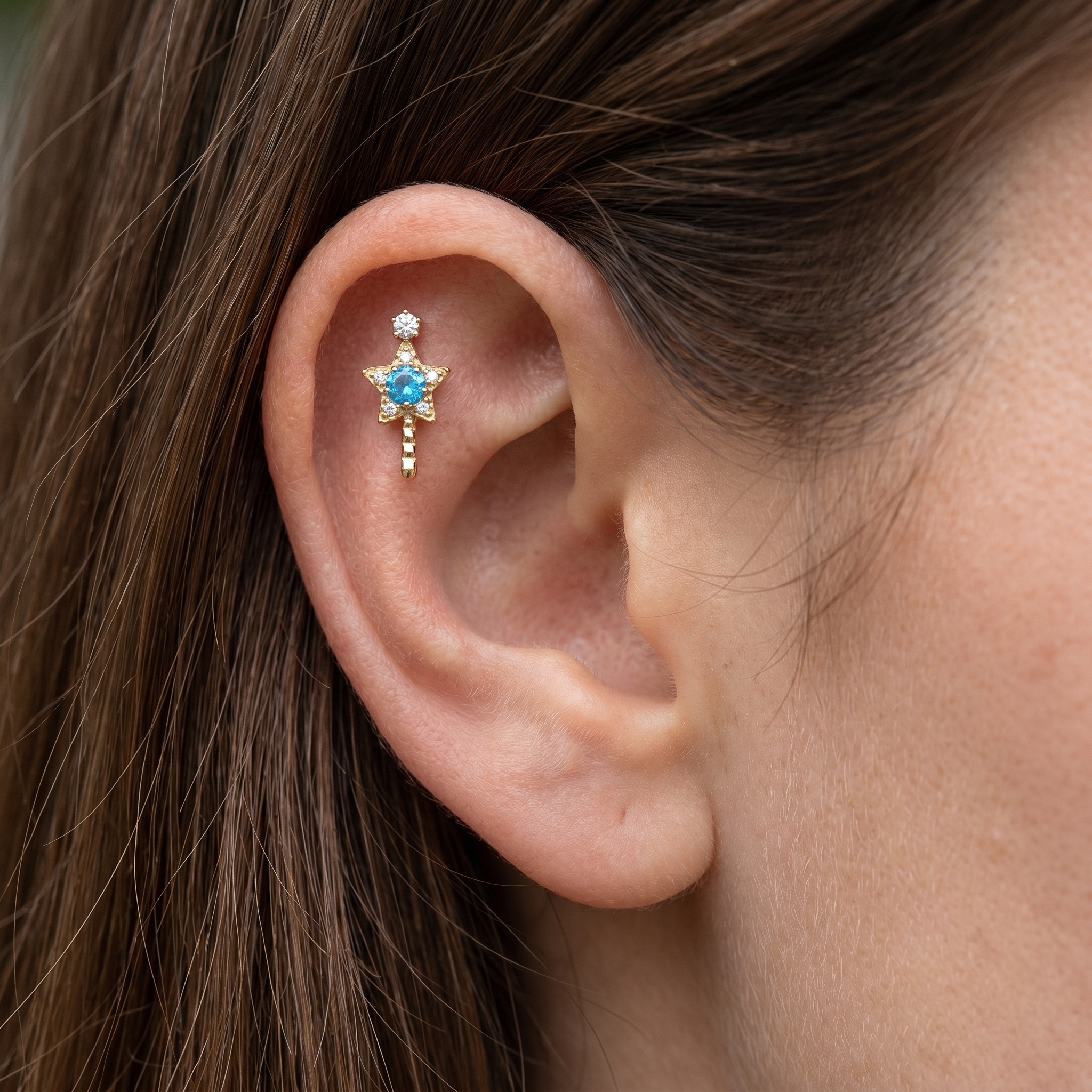 Gold star wand cartilage earring styled cleanly in the upper region of