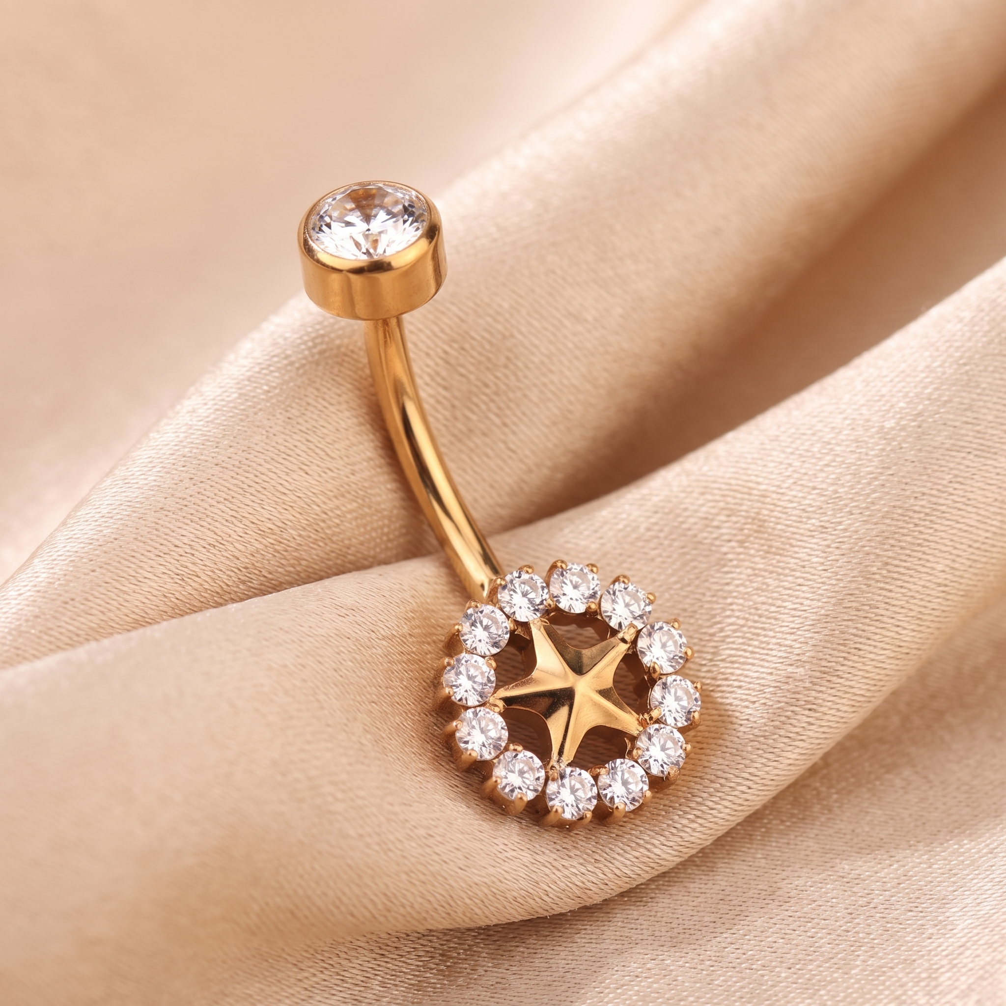 Sunburst belly button ring in gold on champagne satin — G23 titanium 14G