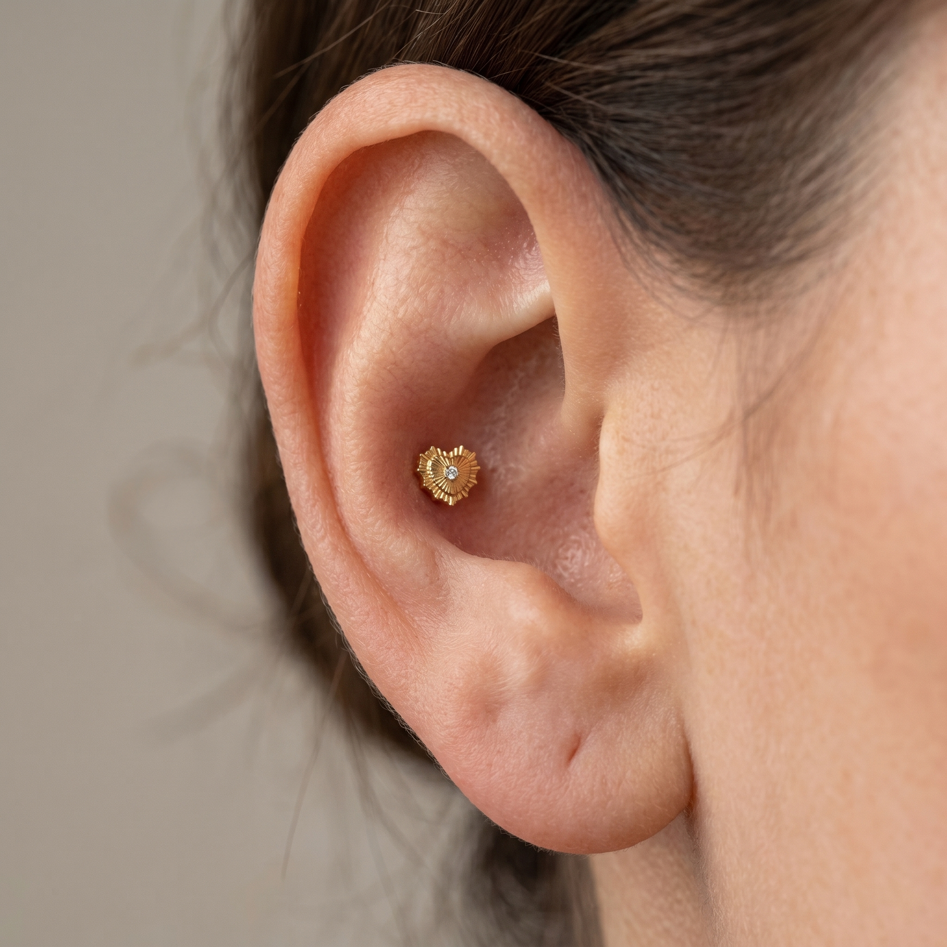 Gold sunburst heart zircon ear piercing jewelry styled securely in the cartilage