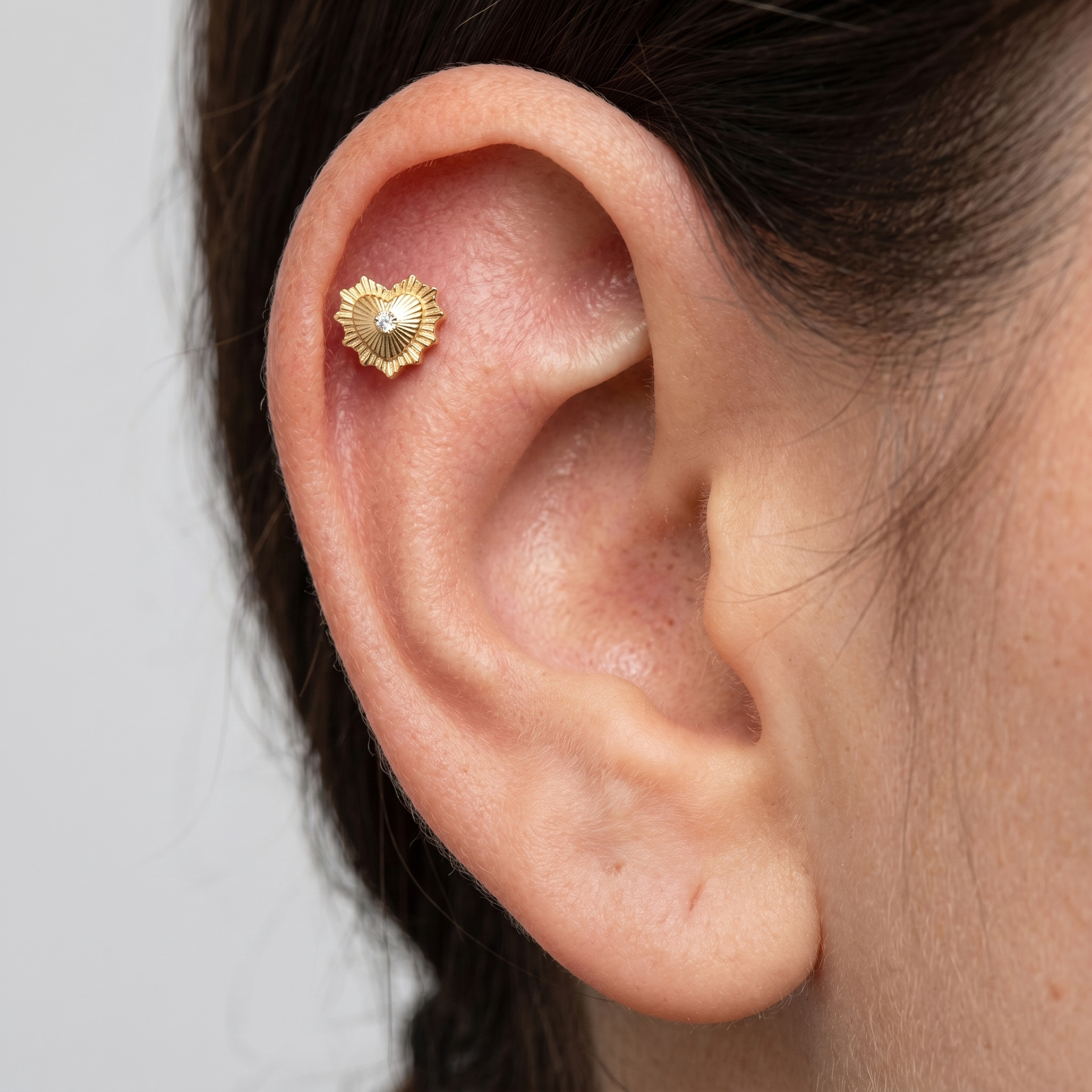 Gold sunburst heart zircon stud — flat helix piercing placement