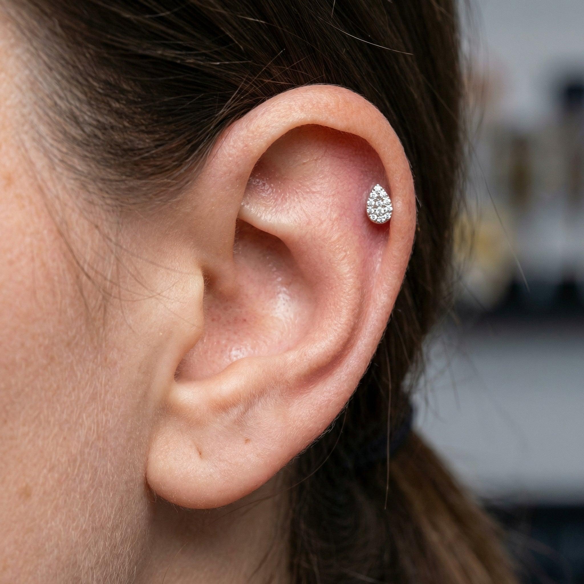 Model showcasing a silver teardrop zircon stud styled cleanly in an upper