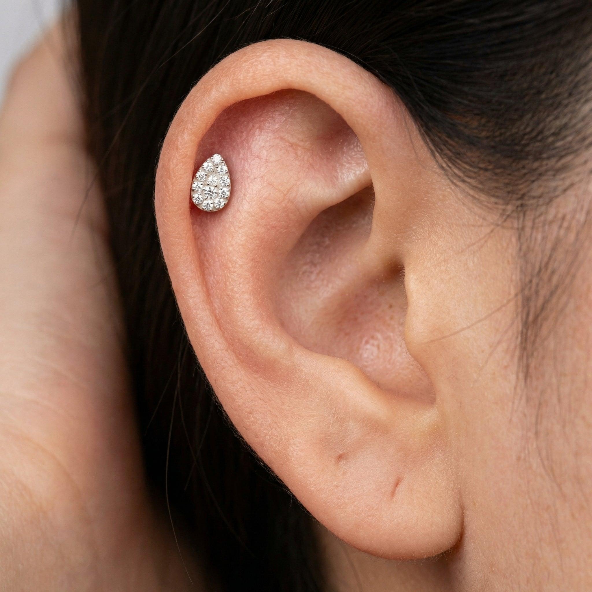 Silver teardrop jewelry piece styled beautifully within the upper cartilage of a