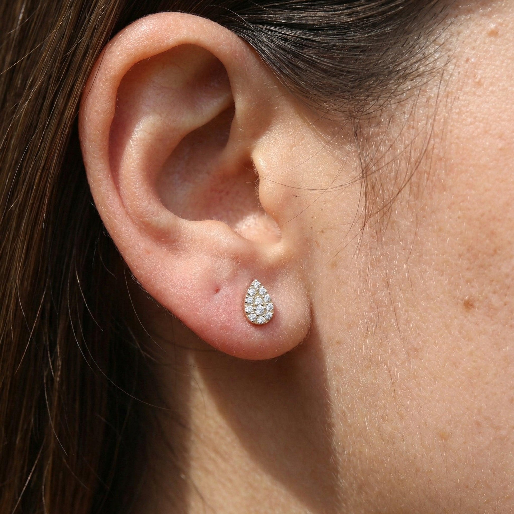 Gold teardrop zircon jewelry styled gracefully in a model's standard lower piercing