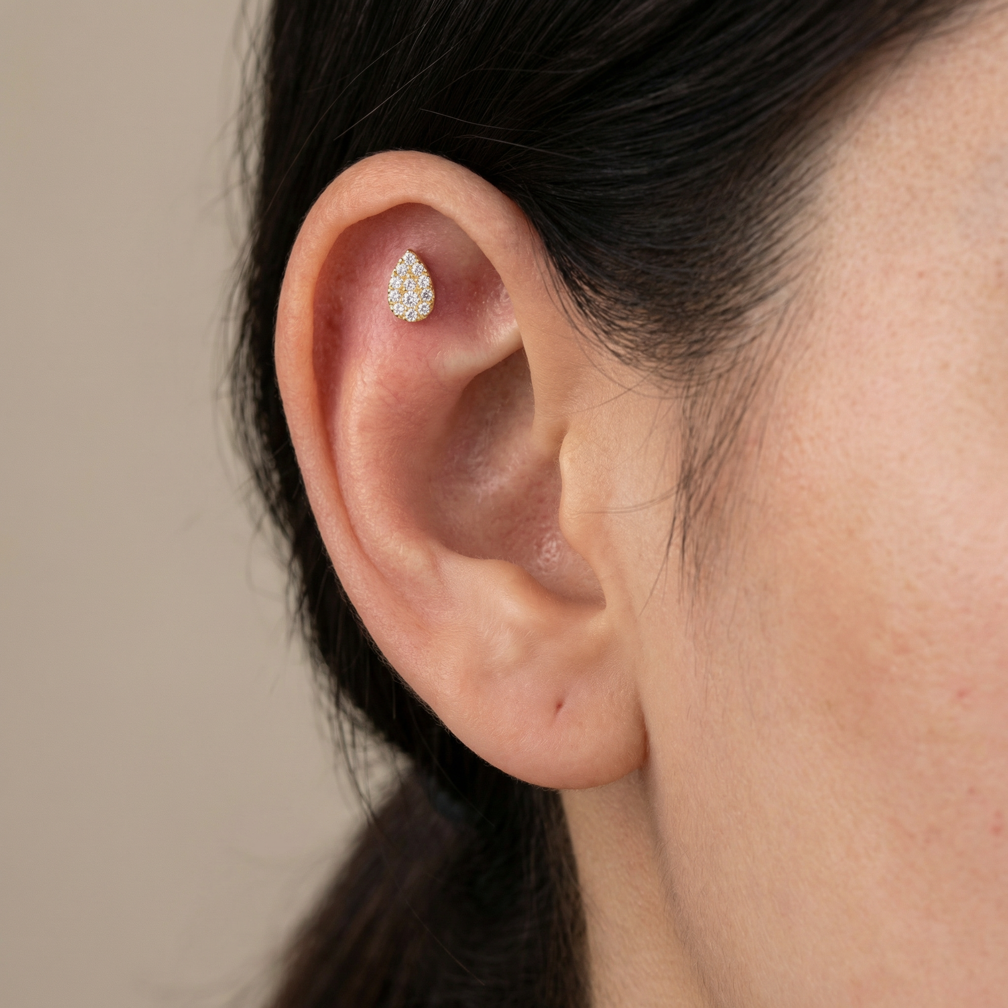 Gold teardrop zircon piercing jewelry styled securely in the upper flat cartilage