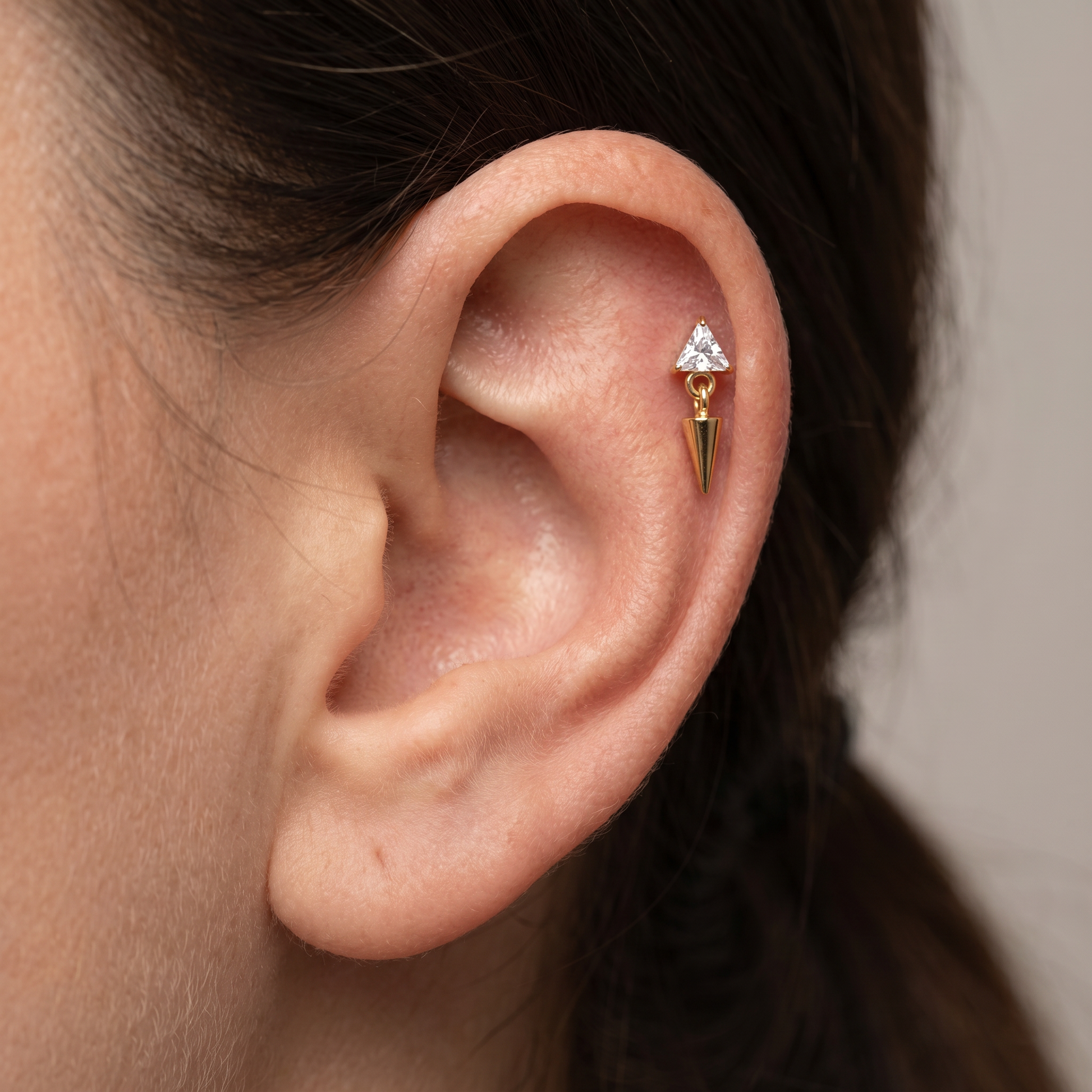Gold triangle zircon spike dangle piercing jewelry styled securely in the upper