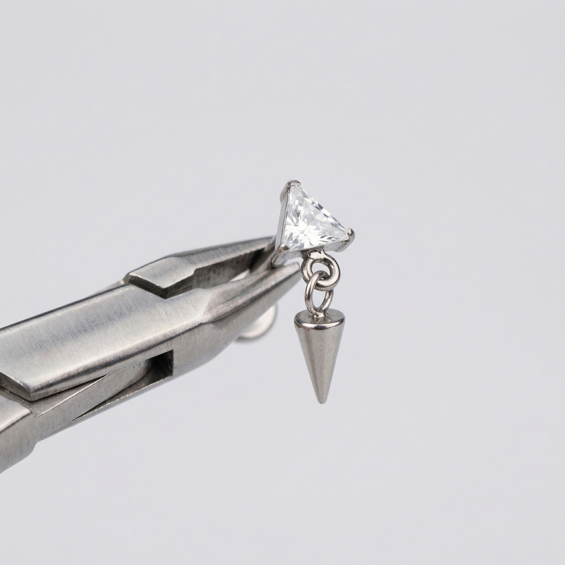 Triangle Front Helix Piercing - Piercing pliers holding a