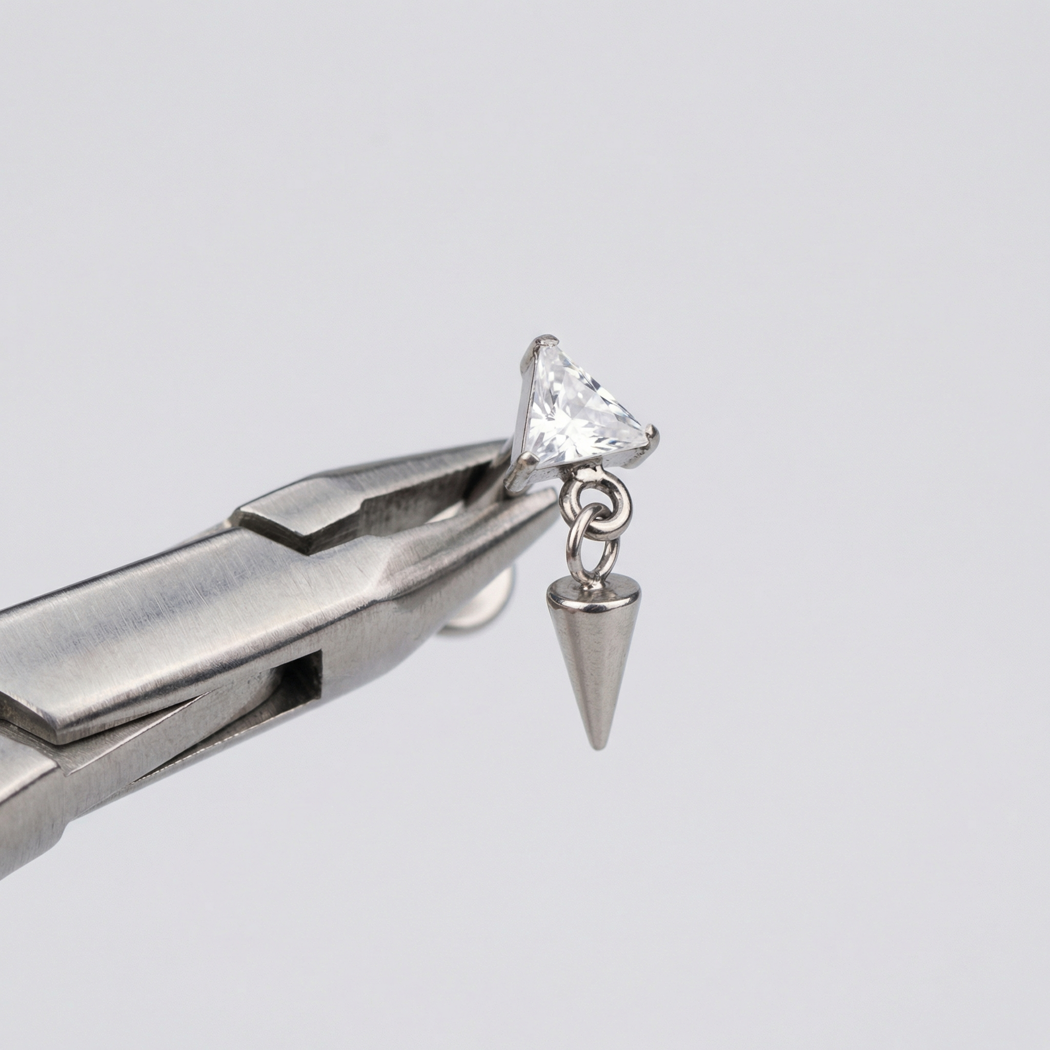 Triangle Front Helix Piercing - Piercing pliers holding a