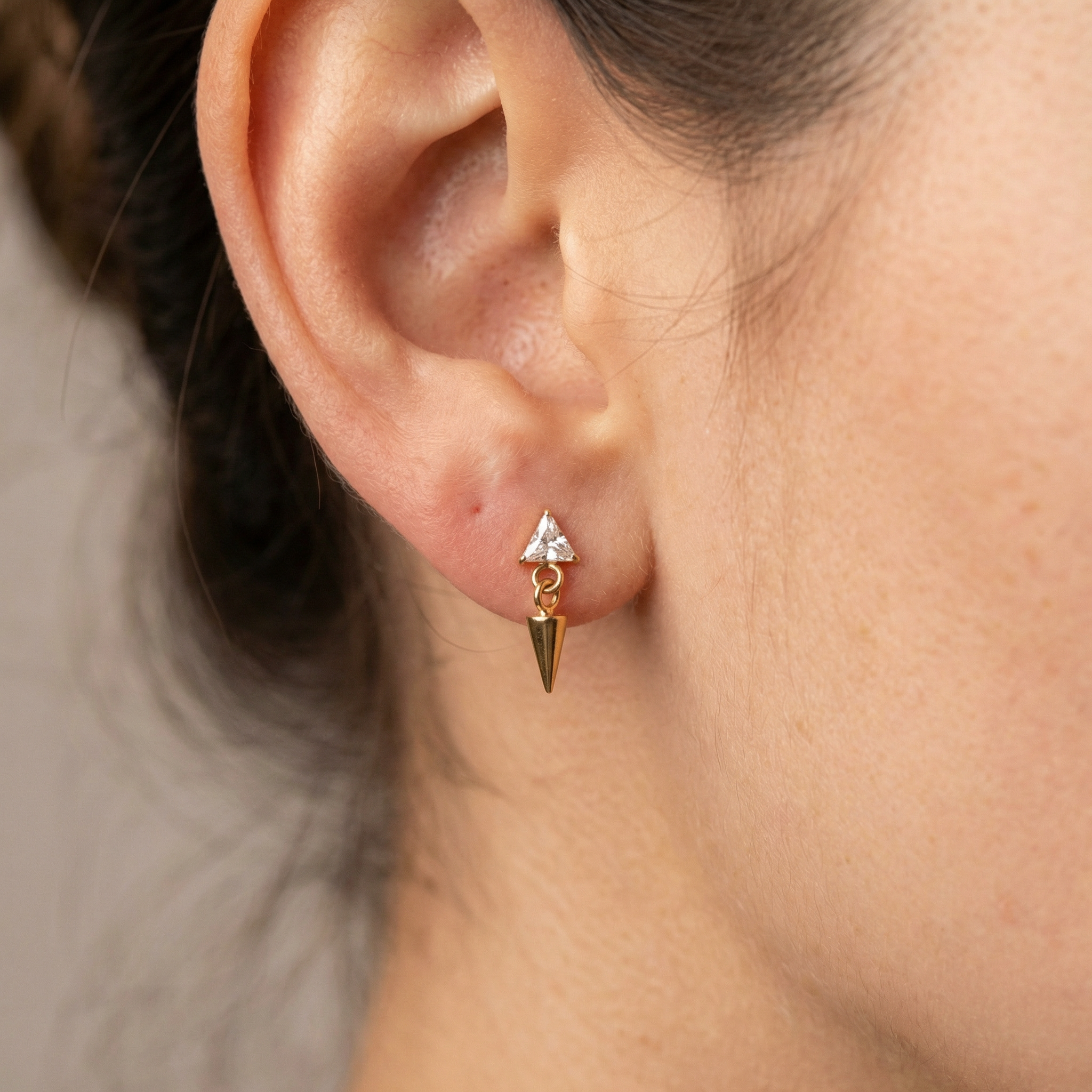 Gold triangle zircon dangling spike jewelry piece styled elegantly in a standard