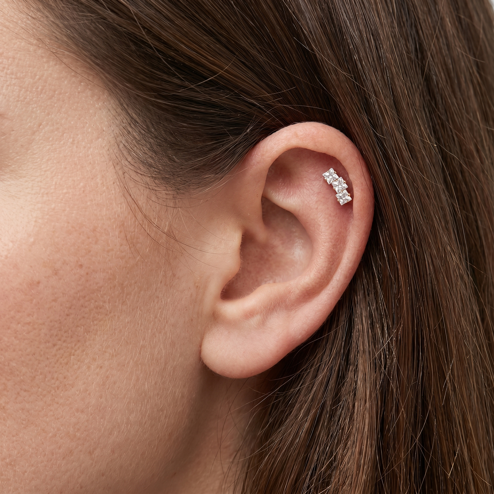Gold minimalist cartilage jewelry styled in a piercing.