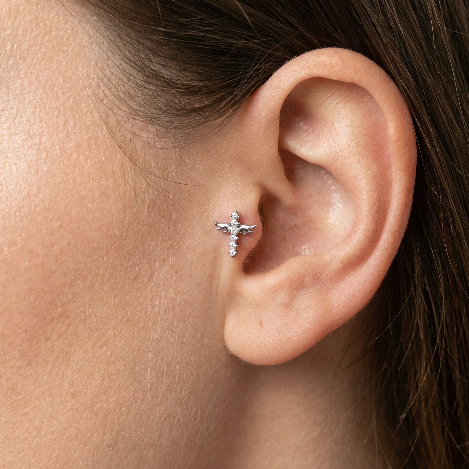 Model wearing a silver titanium winged cross styled elegantly in a standard