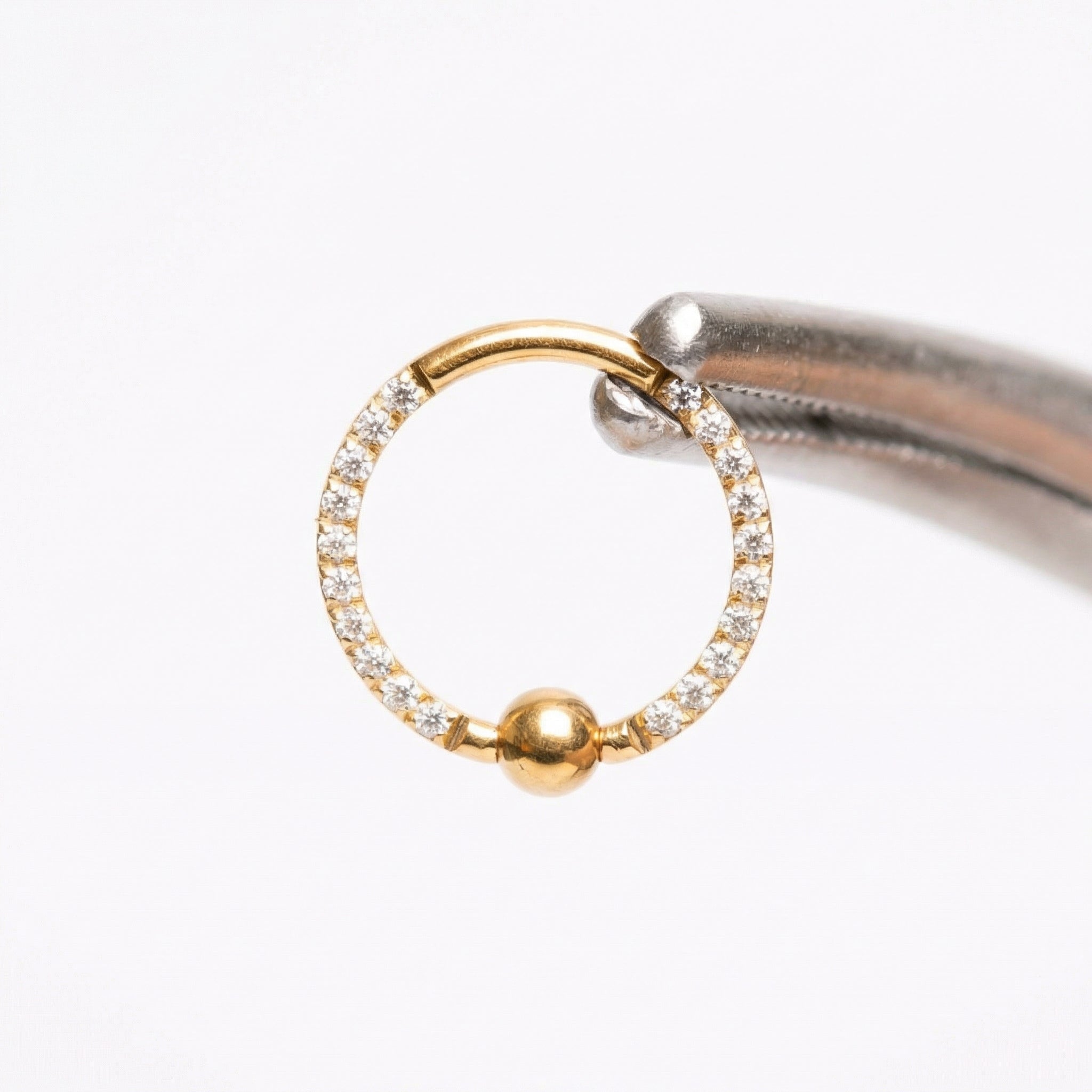 Earrings For A Daith Piercing - Piercing pliers holding a