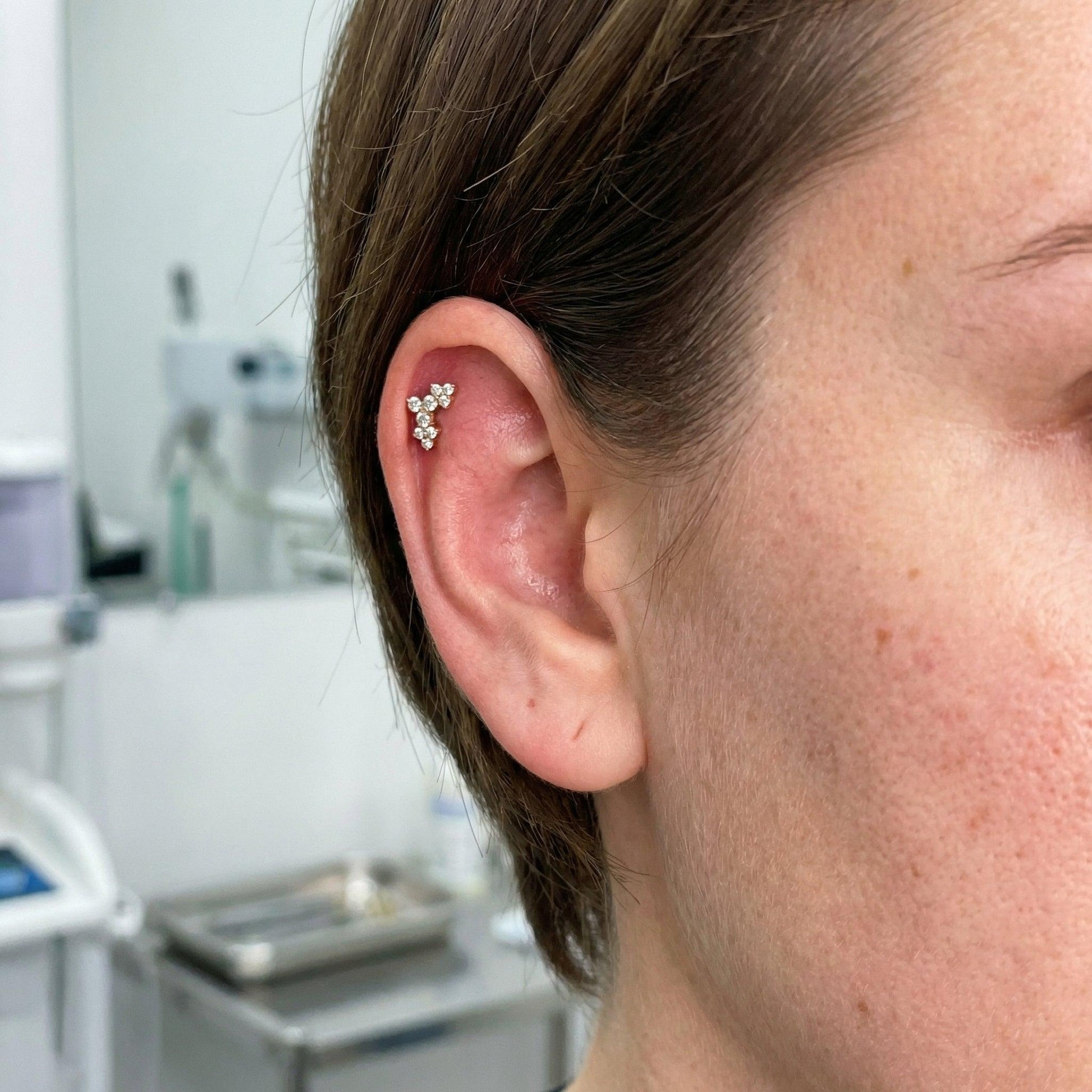 Close-up of a silver elegant cluster worn in a model's outer cartilage