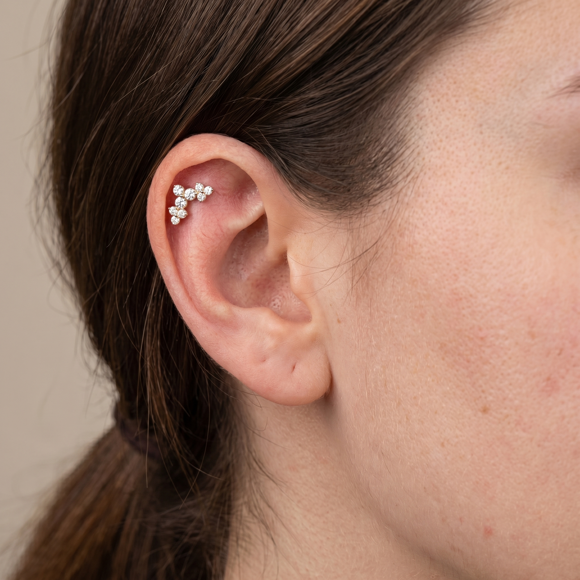 Silver elegant cluster zircon styled perfectly on a model's ear cartilage piercing.