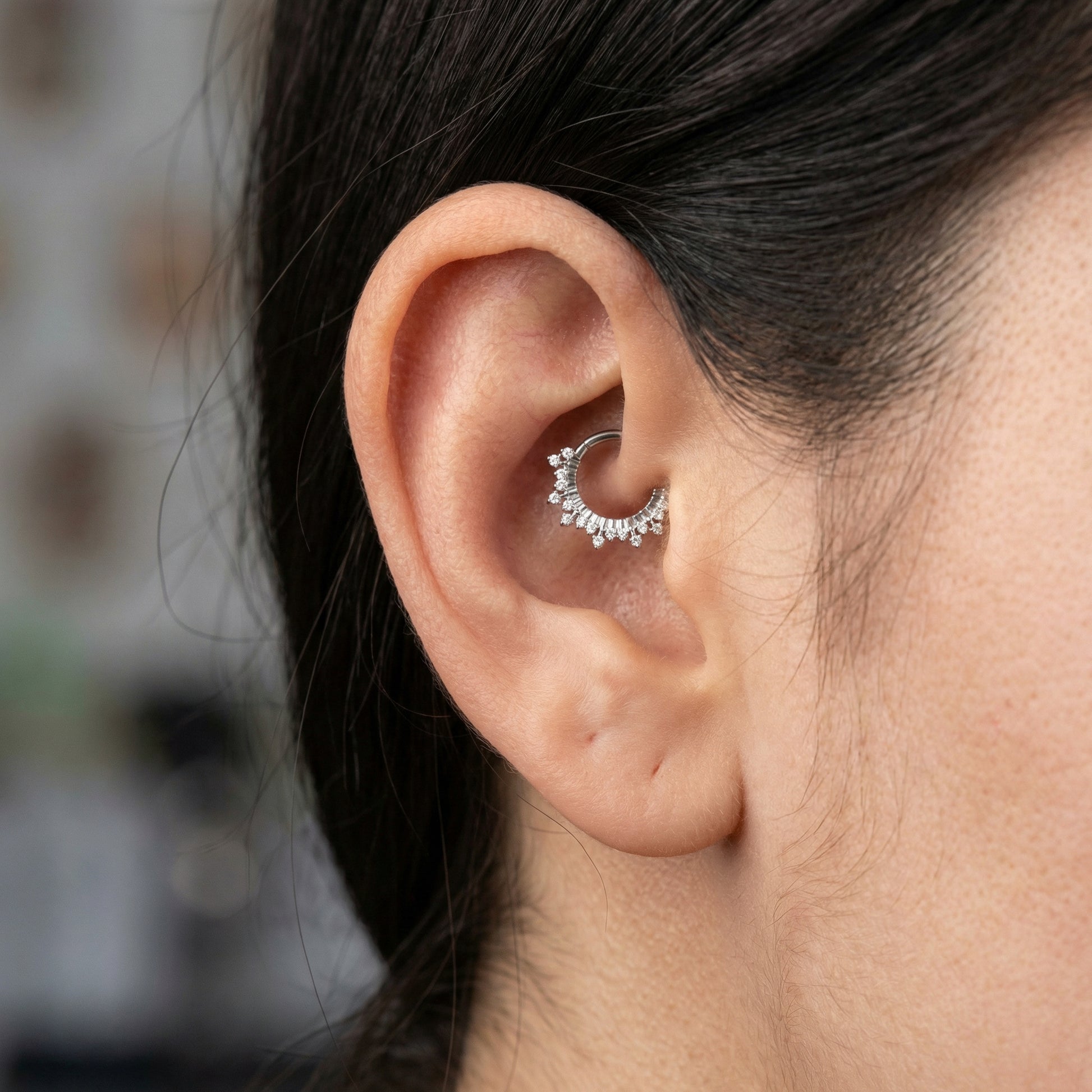 Profile of a model wearing a silver titanium zircon crown clicker in