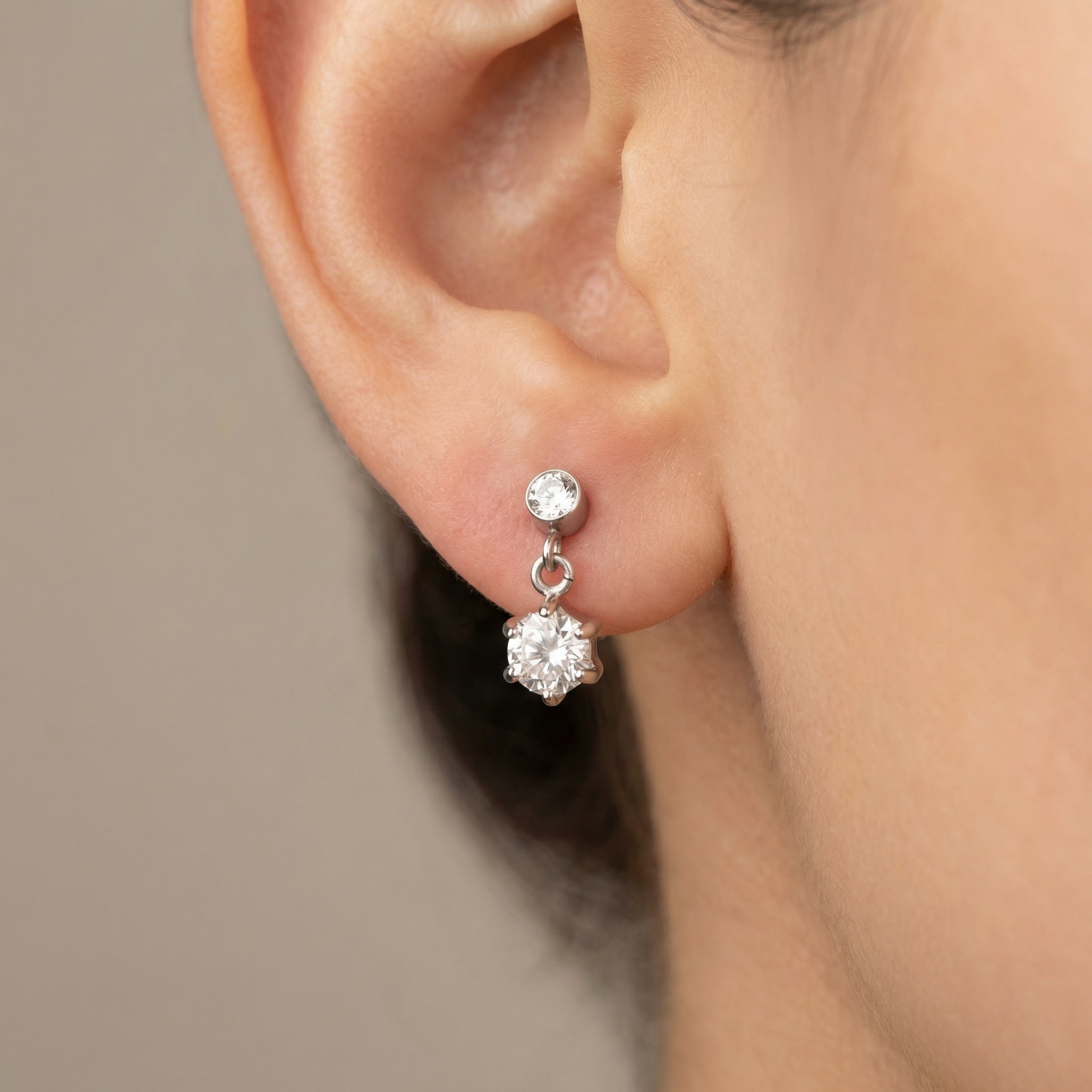 Silver zircon dangle jewelry piece worn in a standard lower piercing.