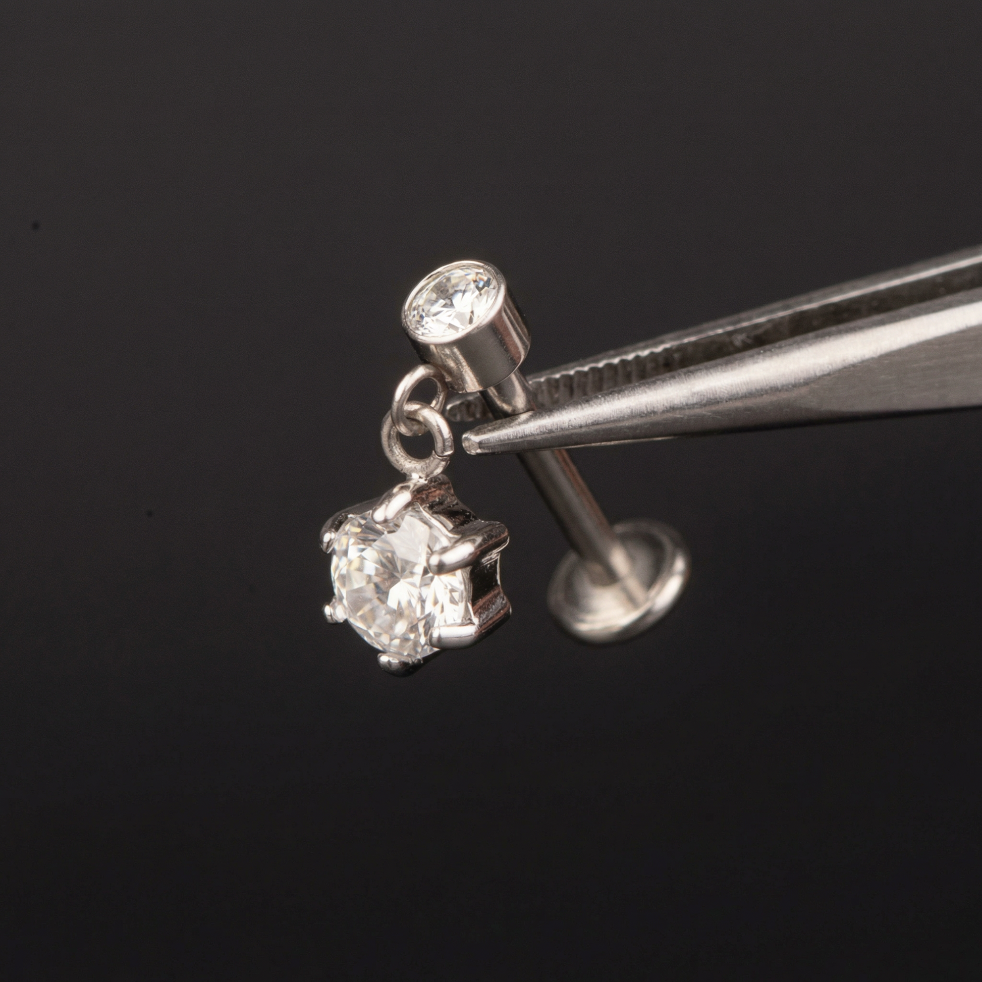 Zircon Hidden Helix Piercing - Precision tweezers holding a