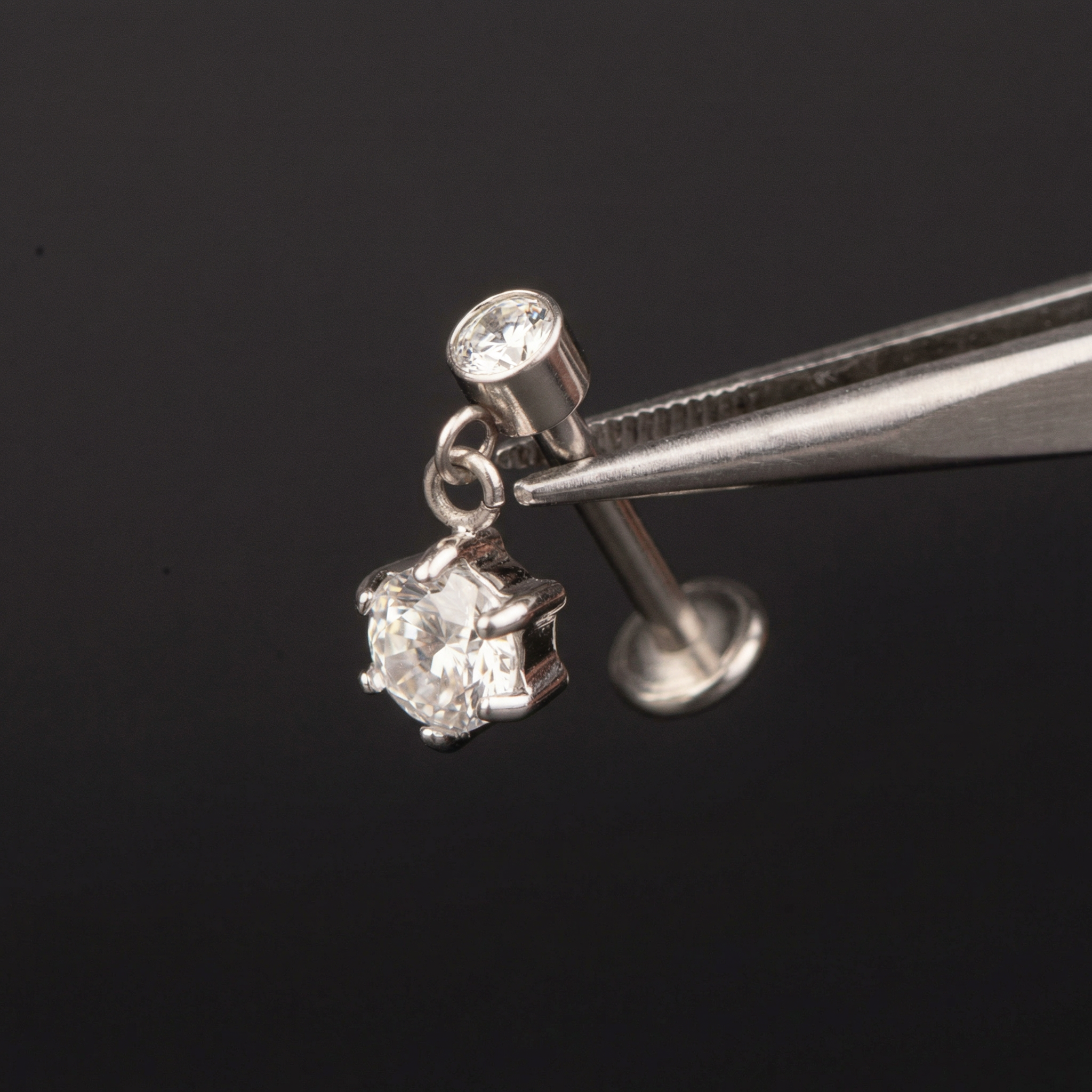 Zircon Hidden Helix Piercing - Precision tweezers holding a