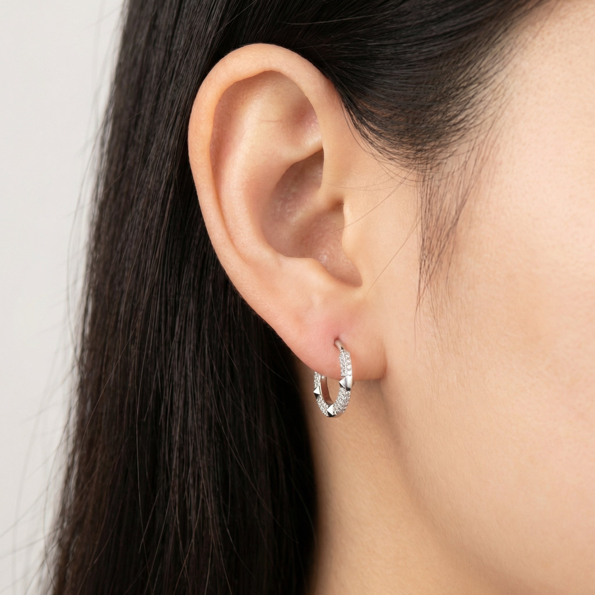 Profile of a model wearing a silver titanium geometric zircon clicker in