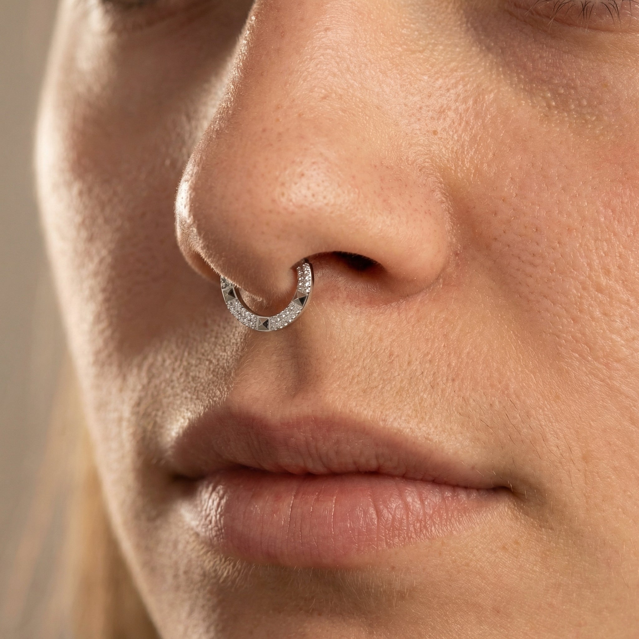Model showcasing a silver geometric zircon clicker perfectly placed in her piercing.