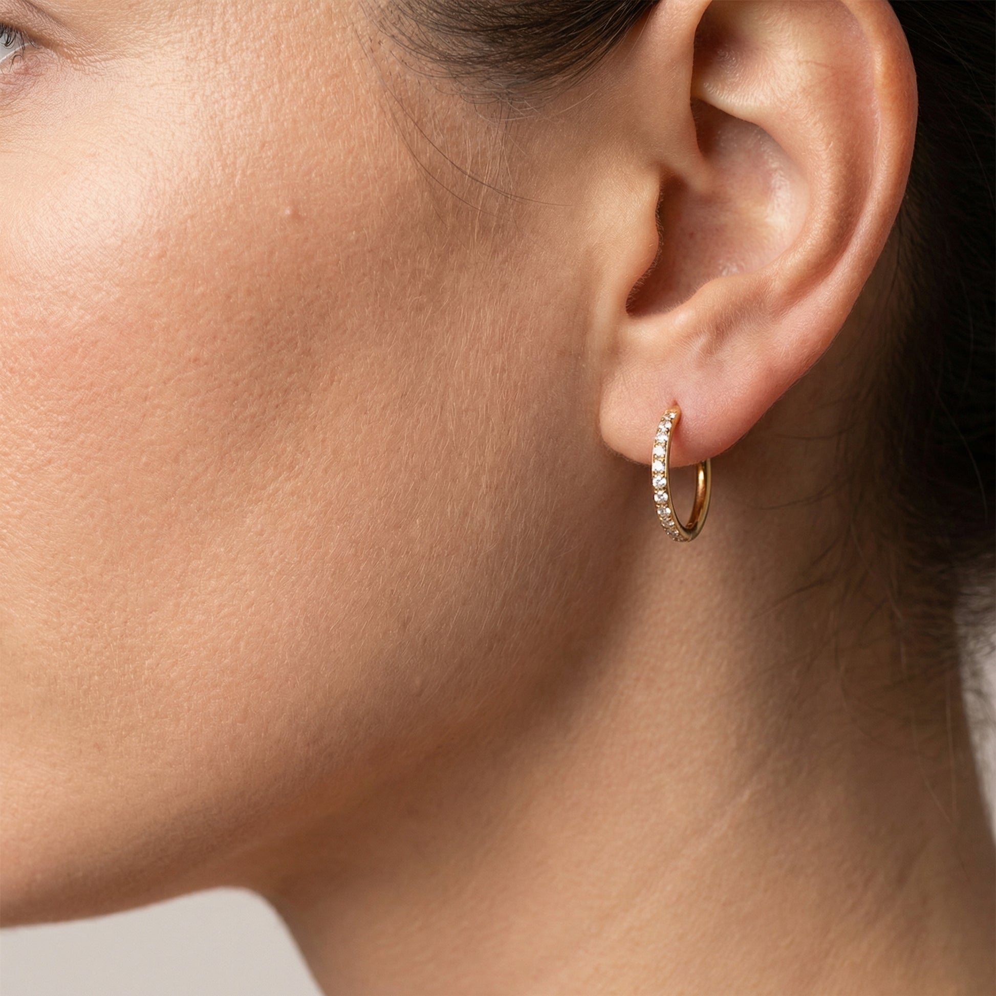 Profile of a model wearing a gold titanium zircon clicker in her