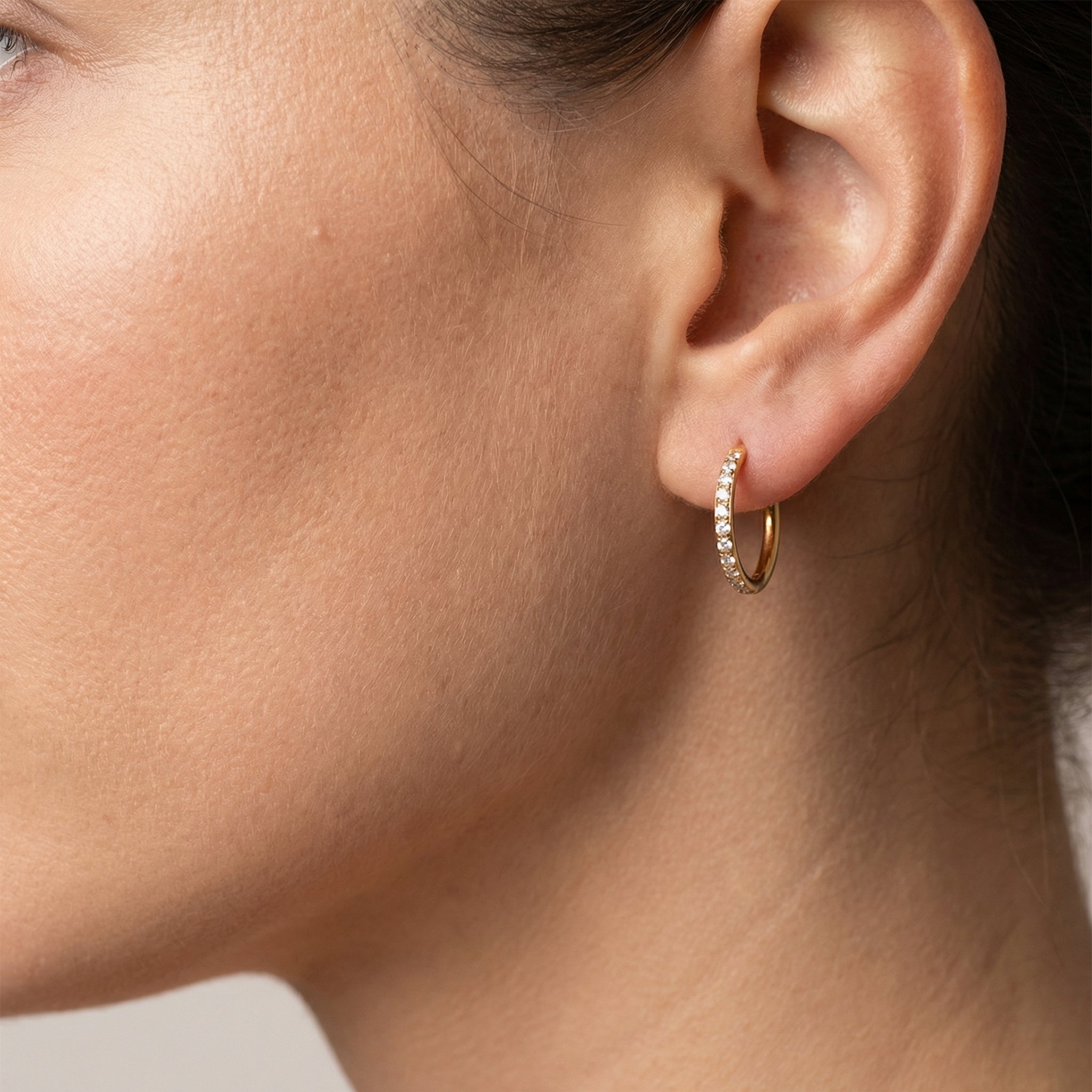 Profile of a model wearing a gold titanium zircon clicker in her