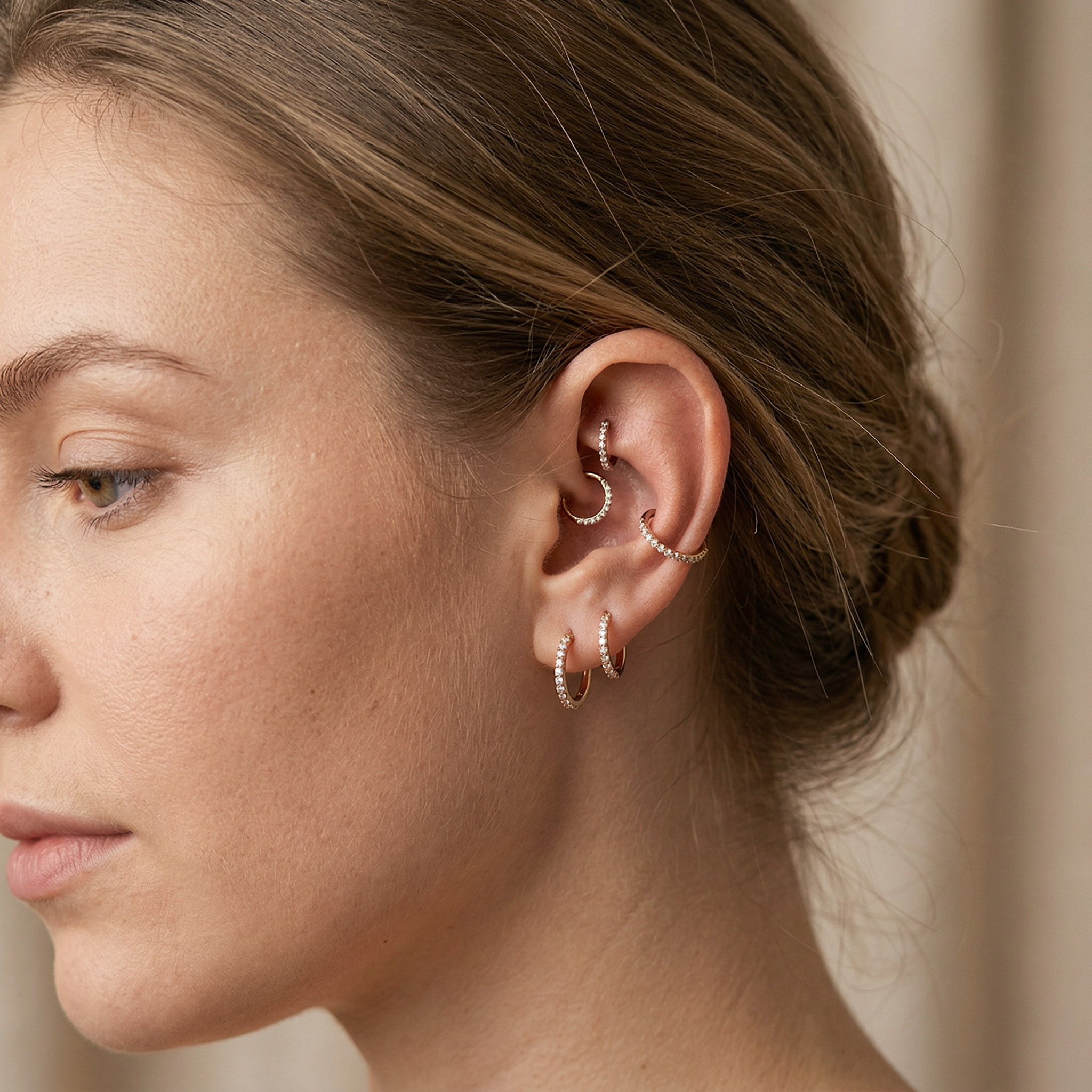 Model optical profile displaying multiple silver zircon clicker hoops throughout her ear