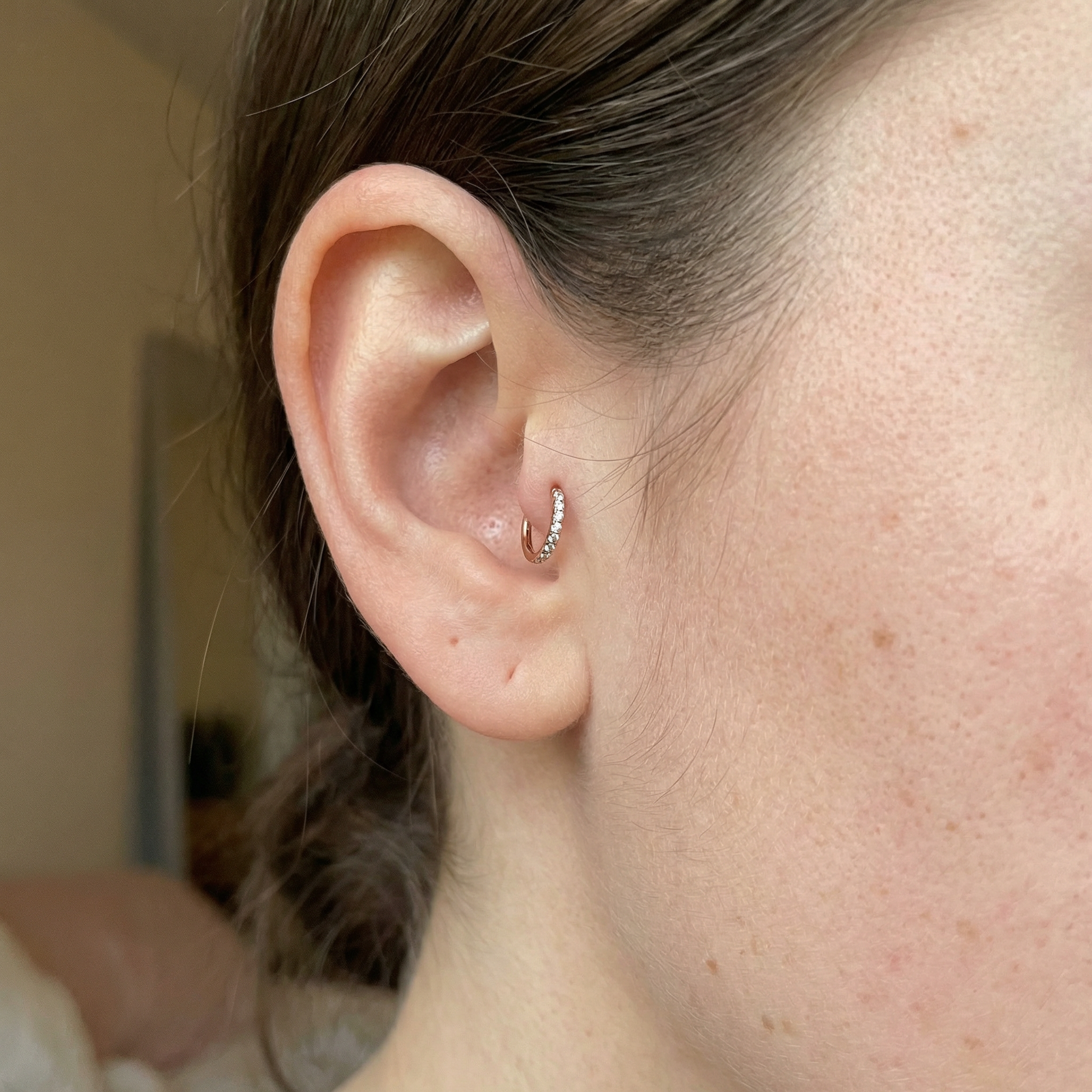 Model showcasing a silver zircon clicker perfectly placed in her inner piercing.